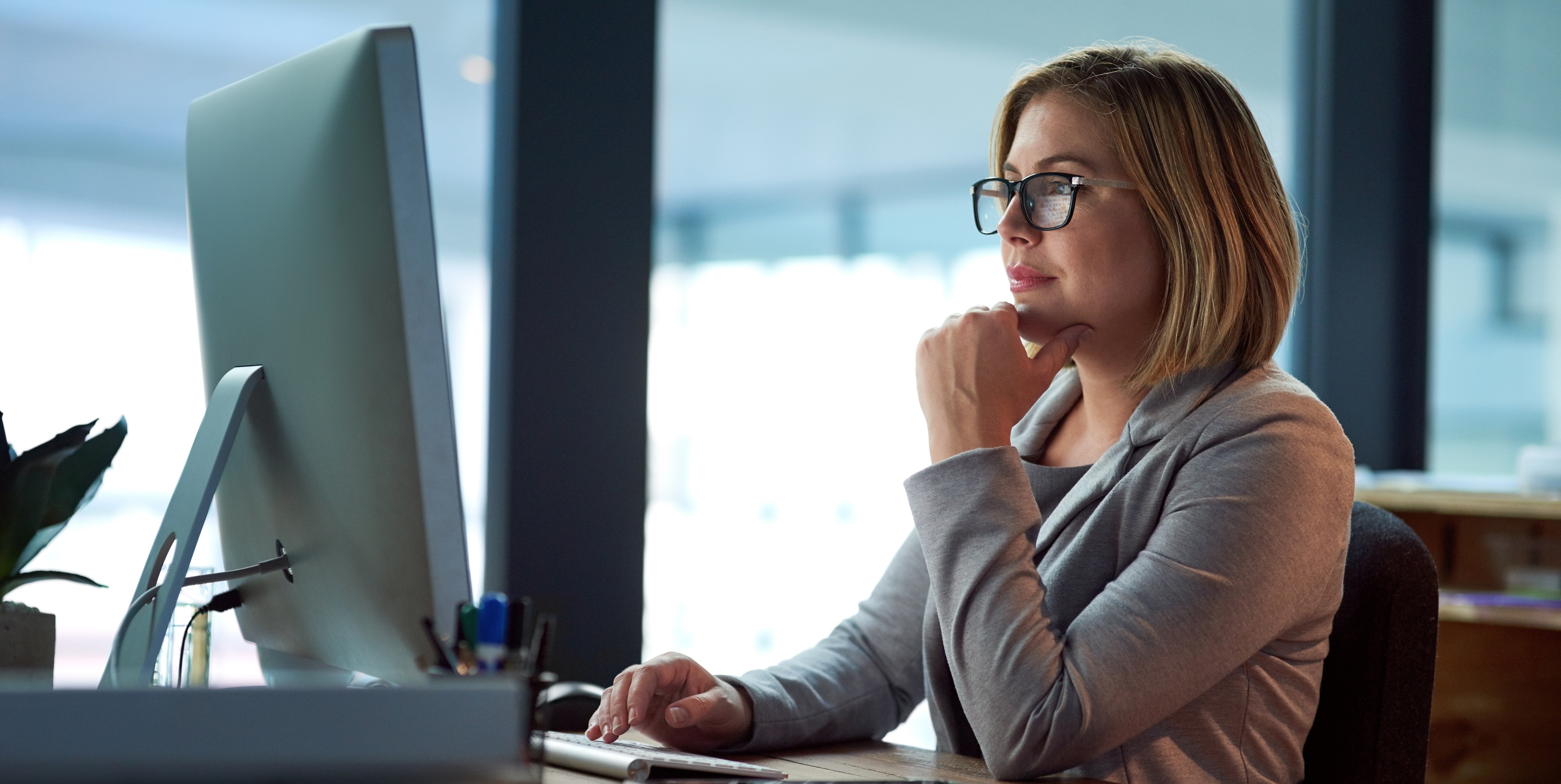 Professional healthcare leader working at a computer, thoughtfully reviewing workforce strategy and operational decisions on their VMS platform.
