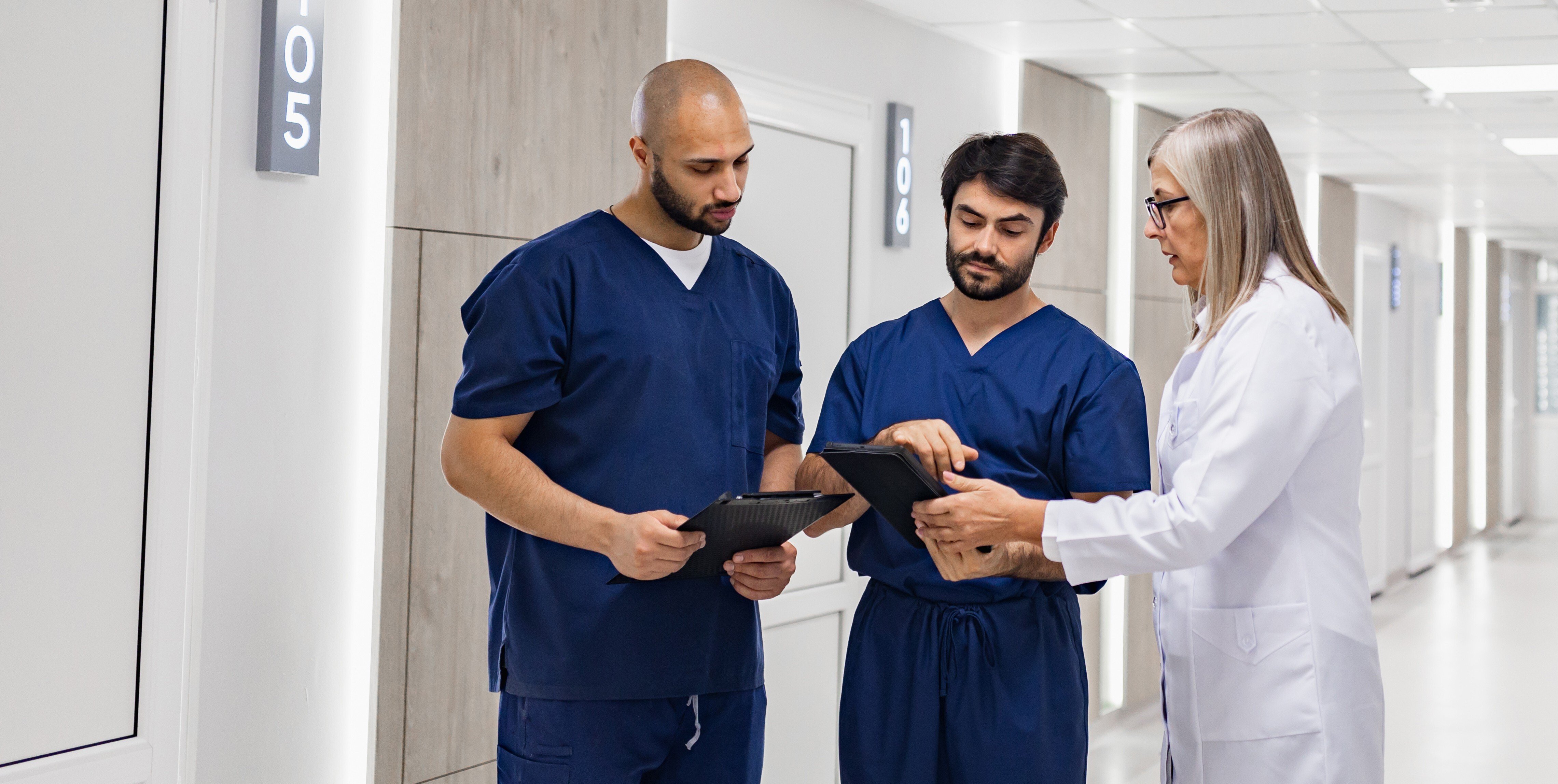 Healthcare team reviewing workforce data in a hospital corridor, representing the labor market trends covered in the May Industry Demand Report.