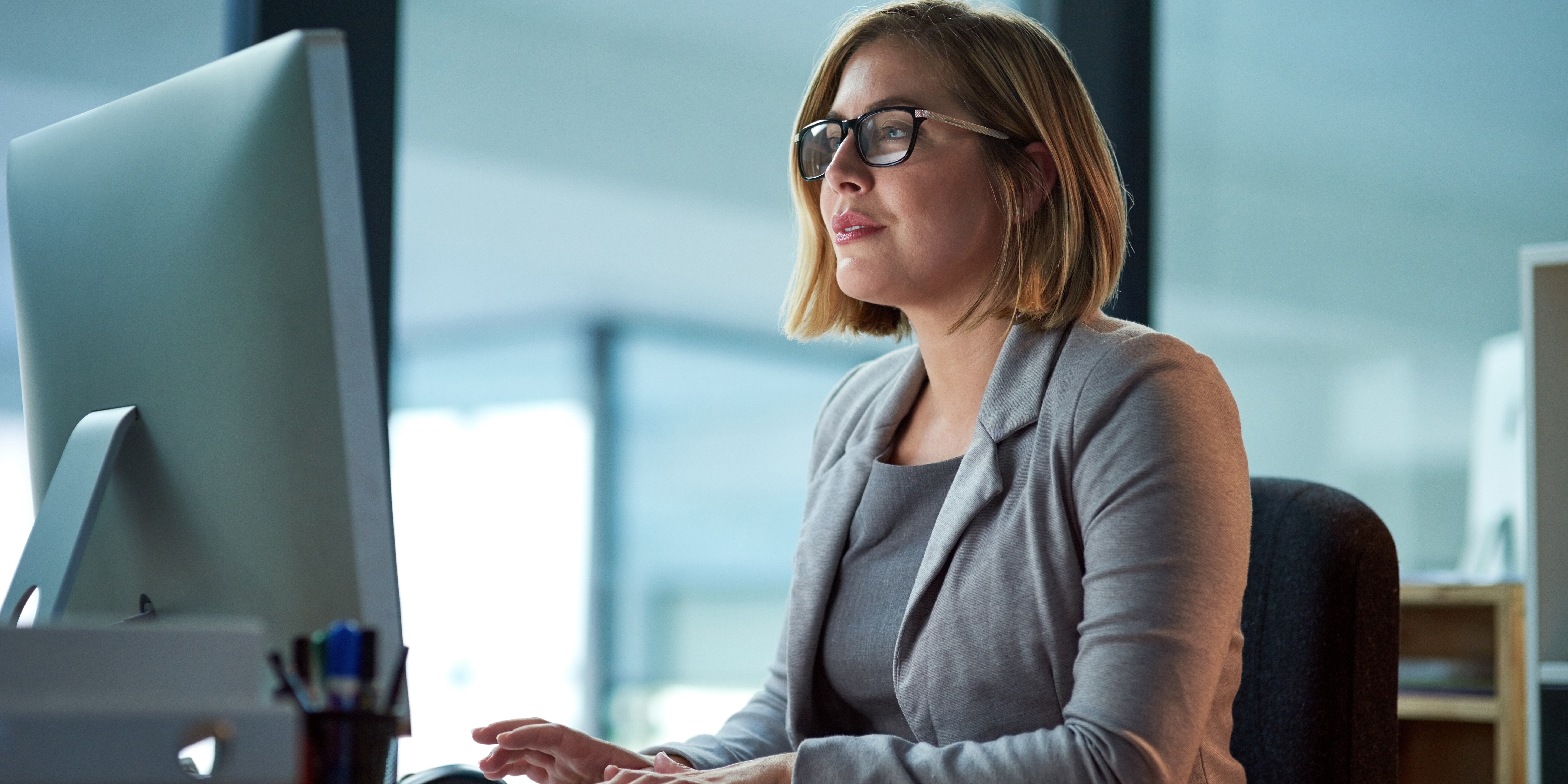 Healthcare workforce leader in glasses and a gray blazer evaluating MSP and VMS program performance ahead of a contract renewal.